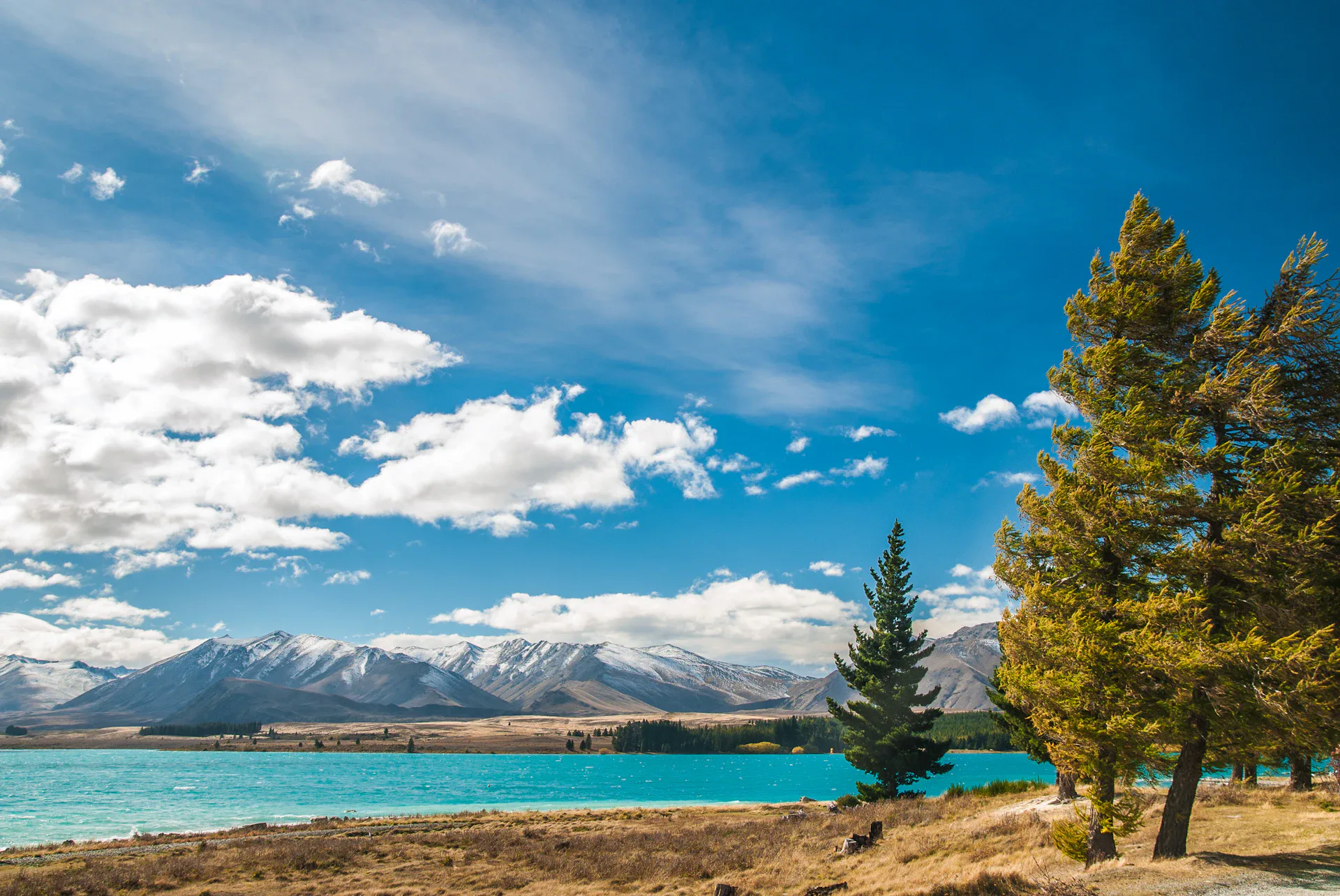 Lake surrounded by mountains under blue sky