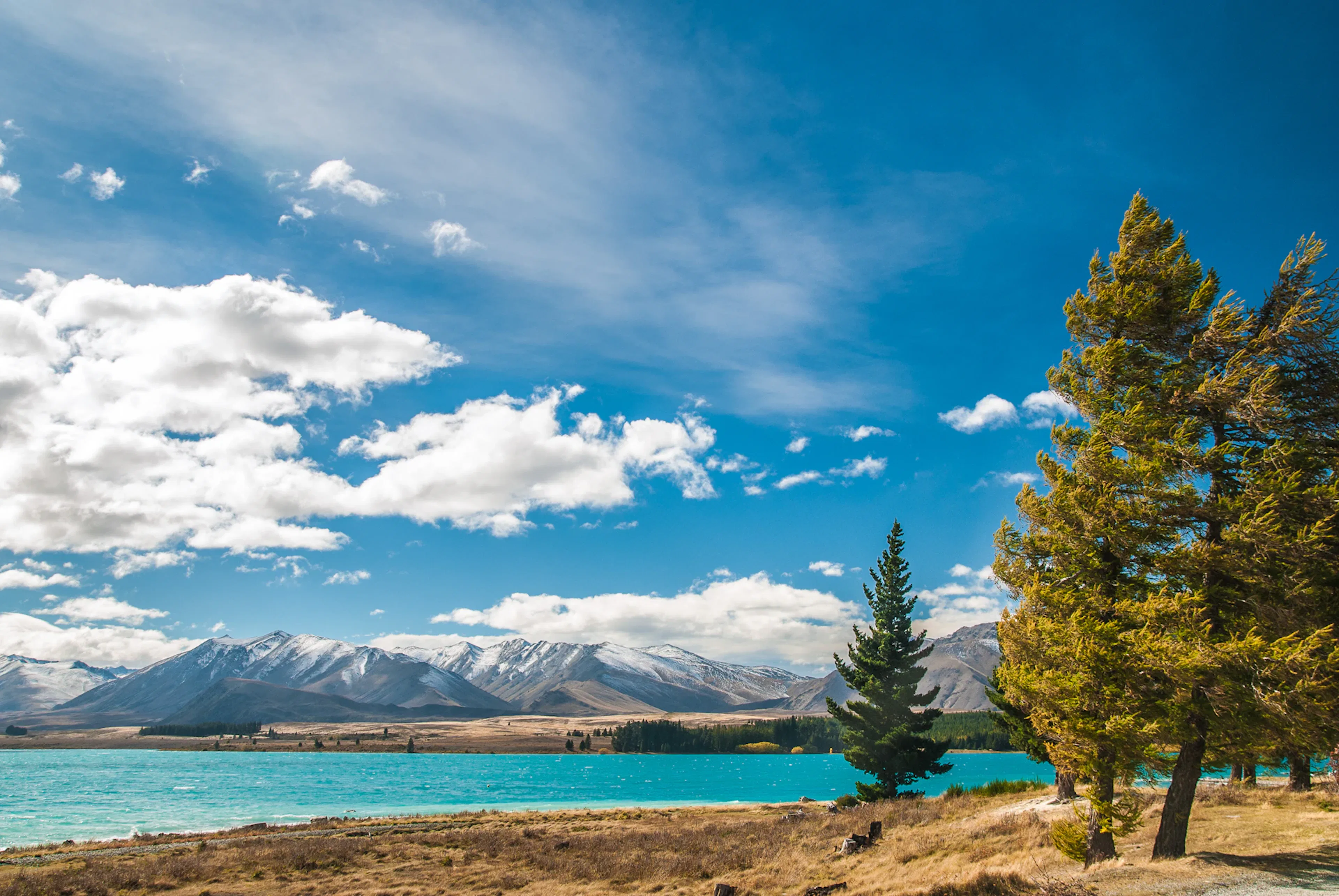 Lake surrounded by mountains under blue sky