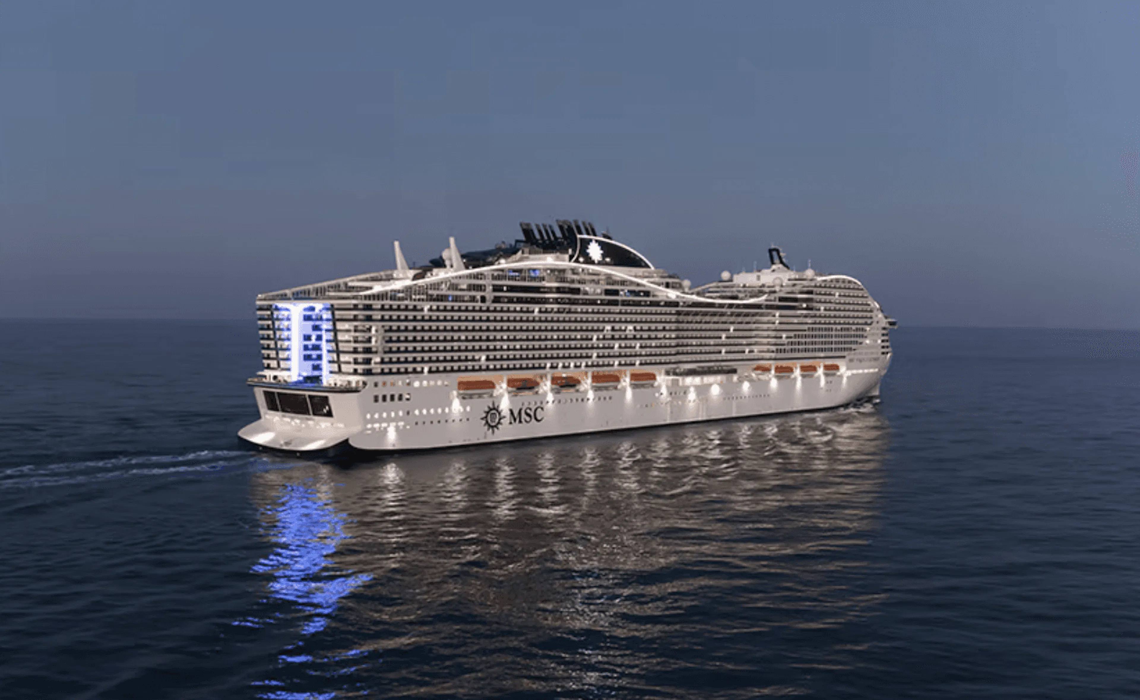 夕暮れの海に浮かぶ、明かりの灯ったMSCの大型客船