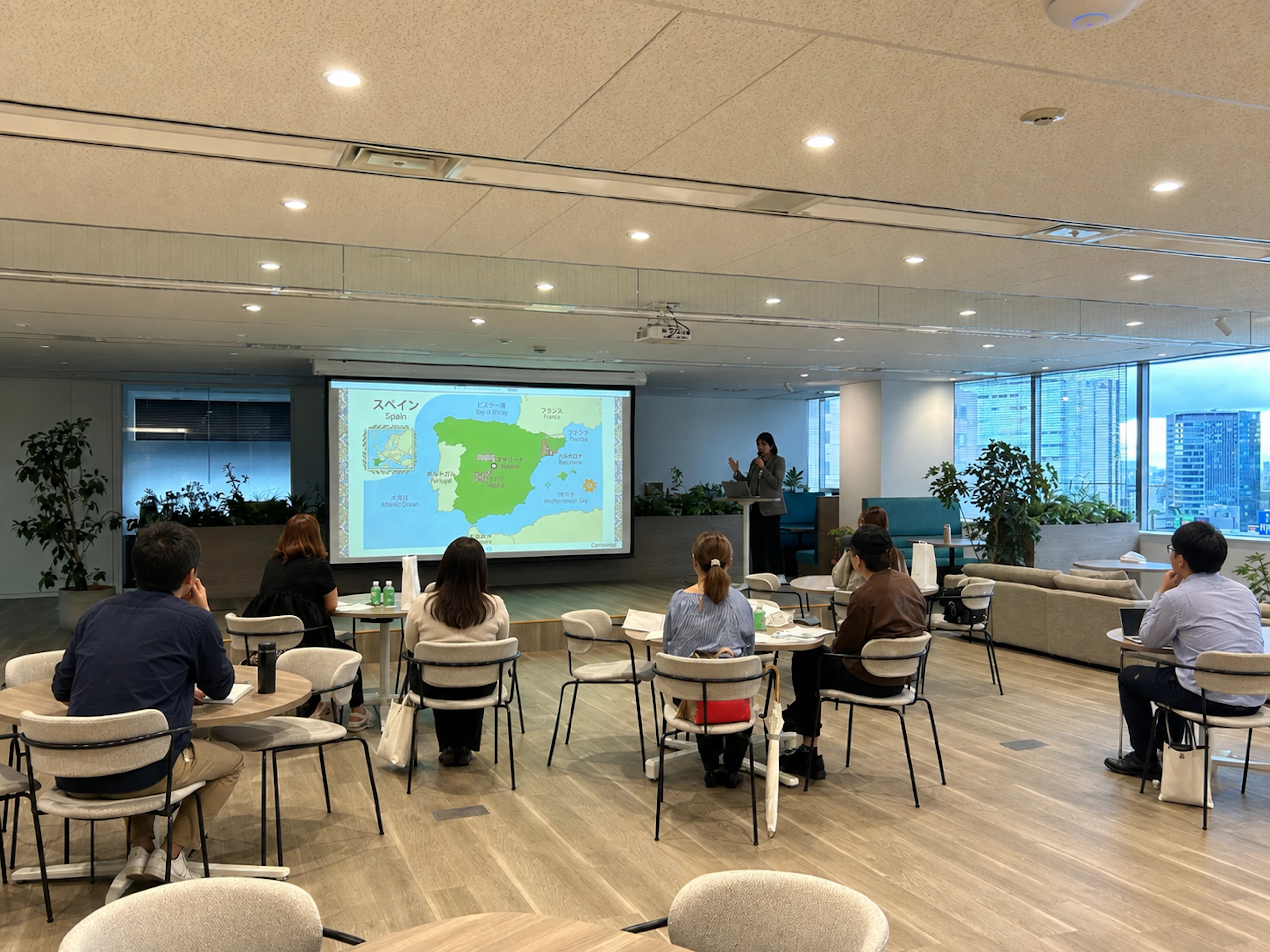 令和トラベルオフィスで開催されたツアー説明会の様子。企画担当者がスペインの地図を投影しながら参加者に説明している